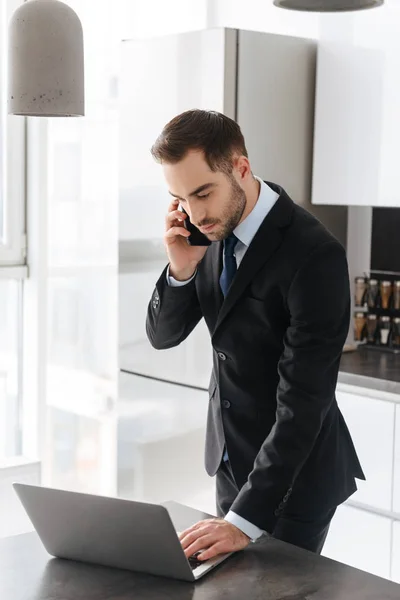 Bild av attraktiv affärsman pratar på mobiltelefon medan wo — Stockfoto