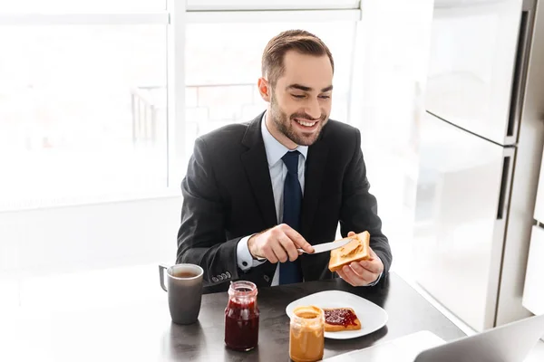 Mutlu işadamının kucakta çalışırken kahvaltı yaptığı görüntü — Stok fotoğraf