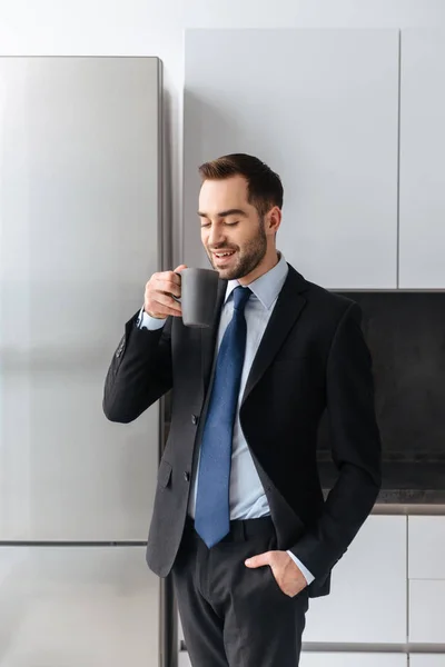 Image of positive businessman holding cup with tea while working — Stock Photo, Image