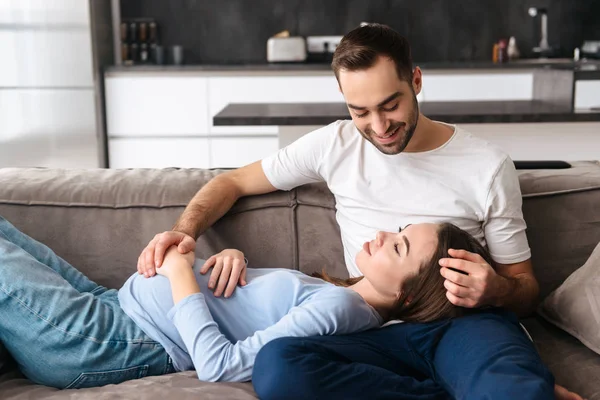 Šťastný mladý těhotný pár v klidu na gauči — Stock fotografie