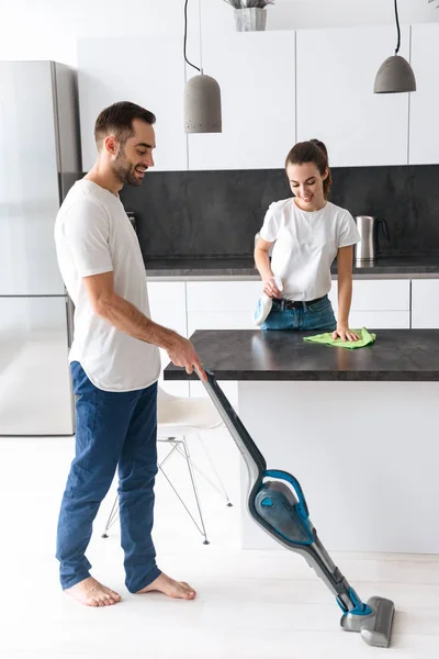 Feliz pareja joven haciendo limpieza general en la cocina —  Fotos de Stock