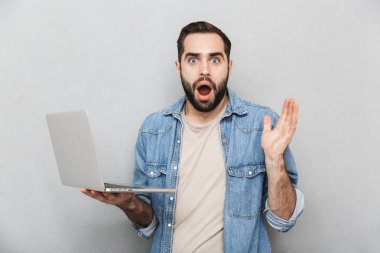 Gri üzerinde izole gömlek giyen şok genç adam