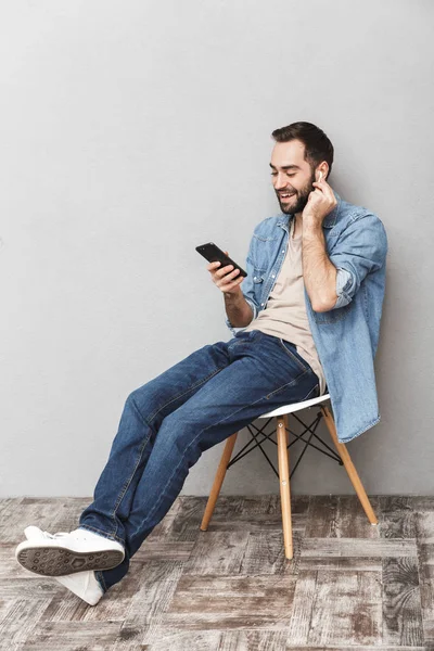 Heyecanlı neşeli adam izole oturan gömlek giyiyor