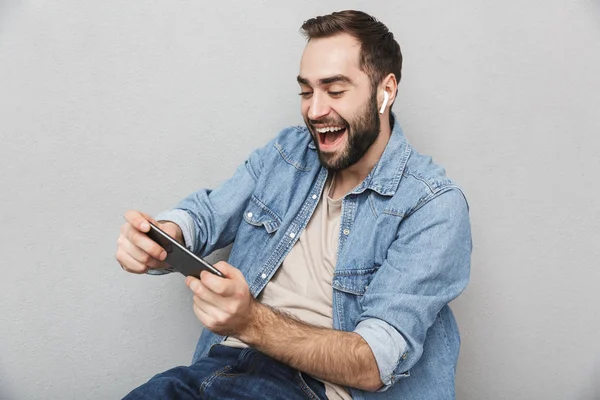 Excited cheerful man wearing shirt standing isolated