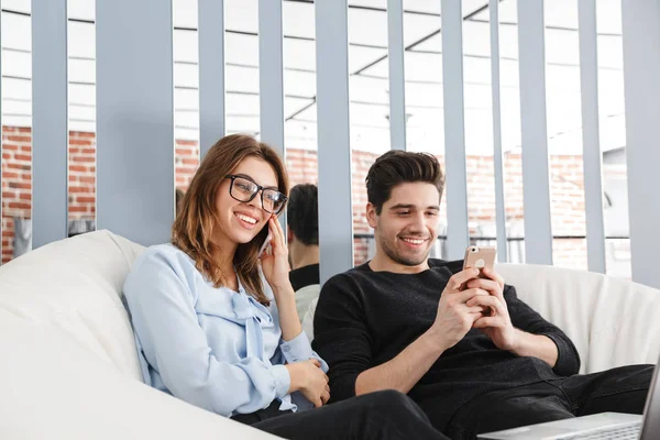 Aimer couple à la maison à l'intérieur en utilisant ordinateur portable bavarder par téléphone . — Photo
