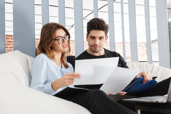 Young loving couple at home indoors using laptop computer work with documents. — Stock Photo, Image