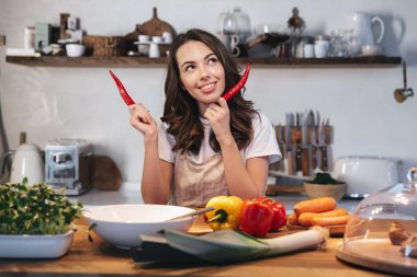 Güzel genç kadın apron pişirme sebze giyiyor