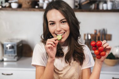 Mutfakta oturan önlük giyen neşeli genç kız