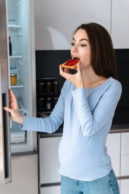 Aç genç hamile kadın tost yiyor