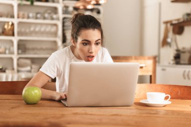 Dizüstü bilgisayar kullanarak elma kapalı şok güzel genç öğrenci kız.