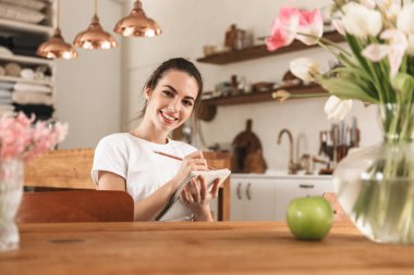 Elma kapalı notlar yazma ile güzel genç öğrenci kız.