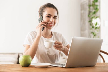 Cep telefonu ile konuşan dizüstü bilgisayar kullanarak kapalı oturan elma ile Öğrenci kız.