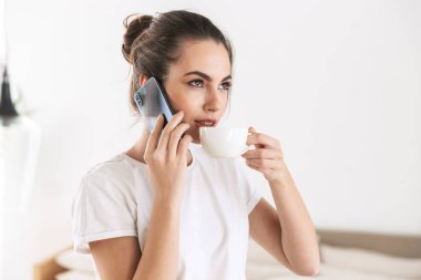 Cep telefonu ile konuşurken kapalı poz kahve içme Öğrenci kız.