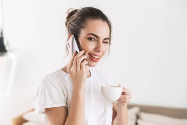 Cep telefonu ile konuşurken kapalı poz kahve içme Öğrenci kız.