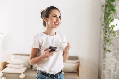 Güzel genç öğrenci kız cep telefonu ile sohbet kapalı poz kahve içme.