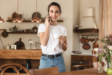 Güzel genç öğrenci kız cep telefonu ile konuşurken kapalı poz.