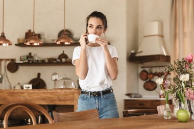 Güzel genç öğrenci kız cep telefonu ile konuşurken kapalı poz.