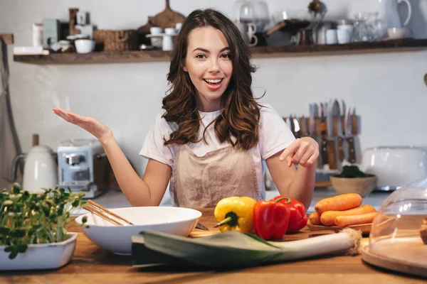 Mulher bonita usando avental cozinhar legumes — Fotografia de Stock