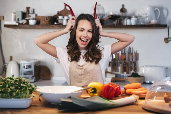 Güzel genç kadın apron pişirme sebze giyiyor