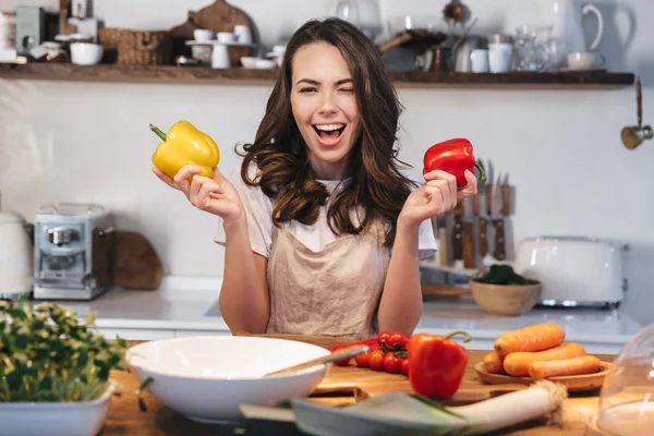 Hermosa mujer joven con delantal cocinar verduras —  Fotos de Stock