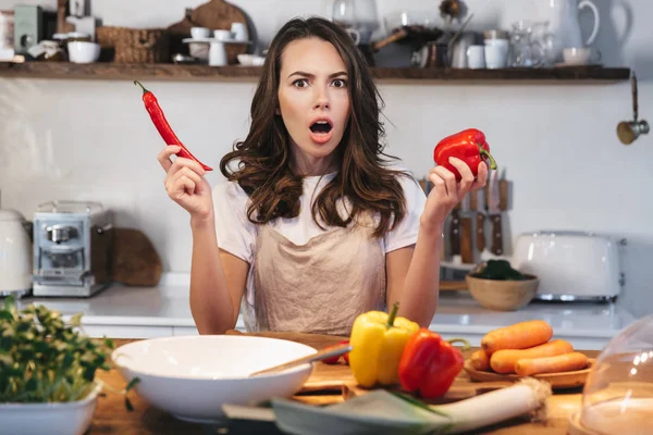 Güzel genç kadın apron pişirme sebze giyiyor