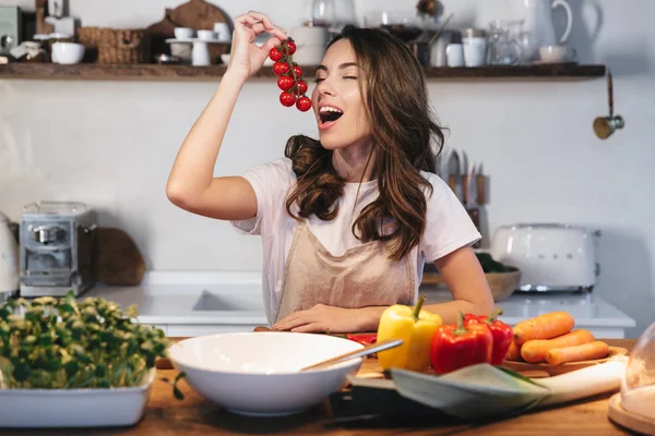 Mulher bonita usando avental cozinhar legumes — Fotografia de Stock