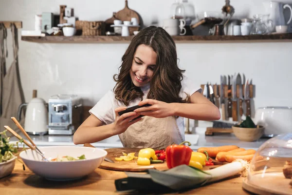 Hermosa mujer joven con delantal cocinar verduras —  Fotos de Stock