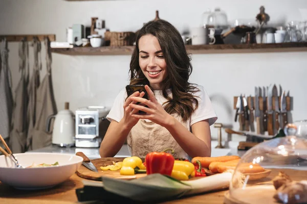 Belle jeune femme portant tablier cuisine légumes — Photo