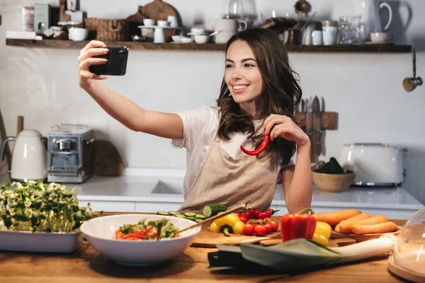 Mulher bonita usando avental cozinhar legumes — Fotografia de Stock