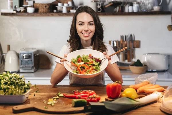 Hermosa mujer joven con delantal cocinar verduras —  Fotos de Stock