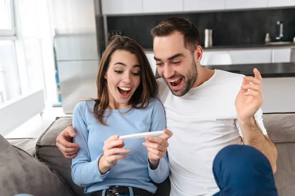 Lovely young couple holdingpregnancy test — Stock Photo, Image