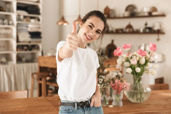 Gyönyörű fiatal diák lány, fehér póló beltéri pózol mutató remek gesztus. — Stock Fotó