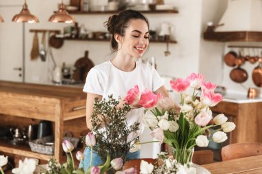 Mutlu genç öğrenci kız çiçeklerin yakınında kapalı poz.