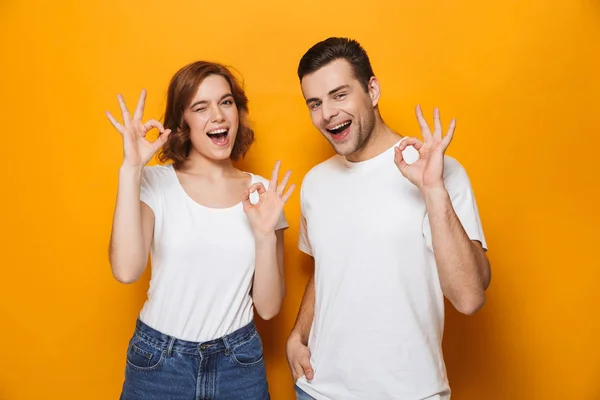 Upphetsad vackert par klädd i vita t-shirts stående — Stockfoto