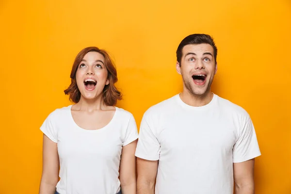 Entusiasmado belo casal vestindo camisetas brancas de pé — Fotografia de Stock