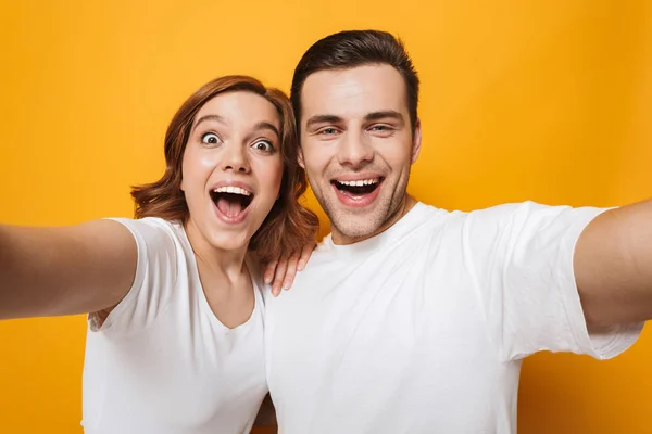 Excited beautiful couple wearing white t-shirts standing — Stock Photo, Image