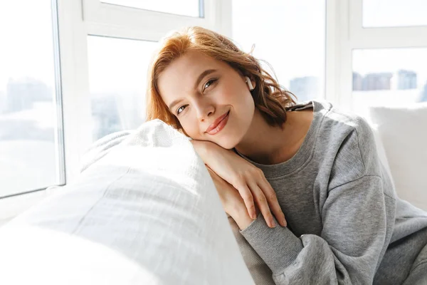 Lovely young woman relaxing on a couch at home — Stock Photo, Image