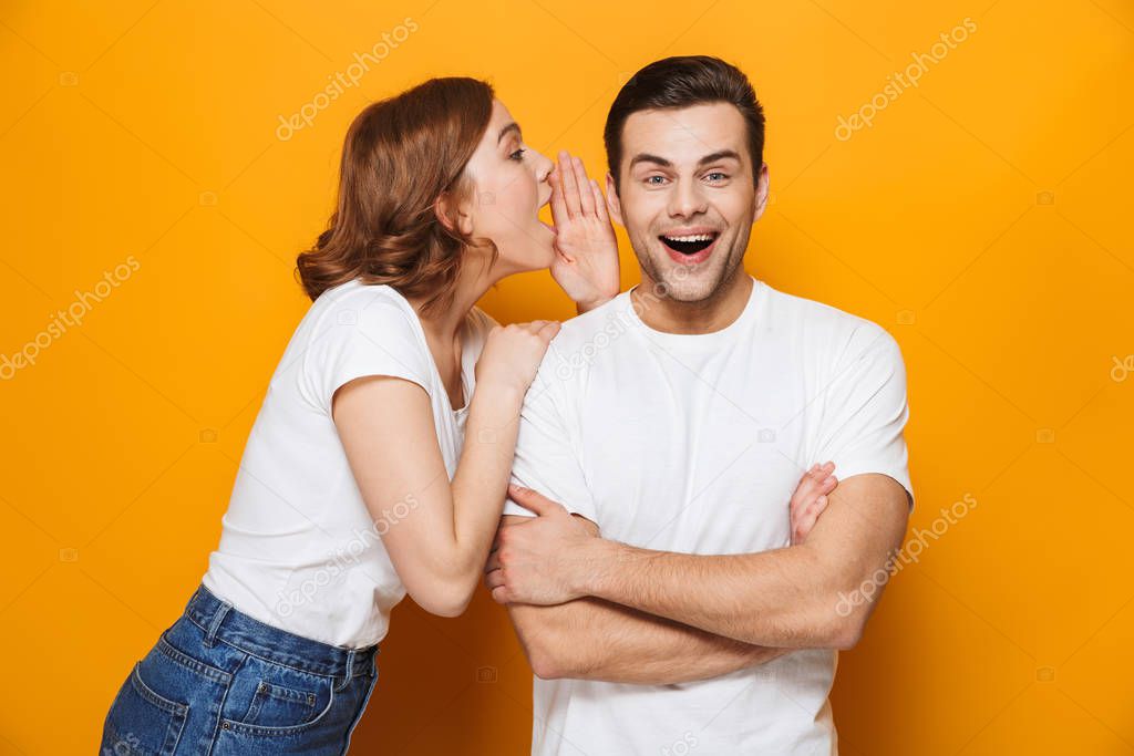 Excited beautiful couple wearing white t-shirts standing