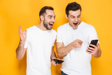 Boş t-shirt giyen iki neşeli heyecanlı erkek arkadaşlar