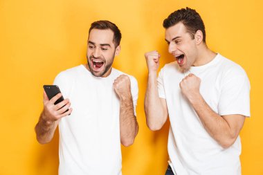 Boş t-shirt giyen iki neşeli heyecanlı erkek arkadaşlar