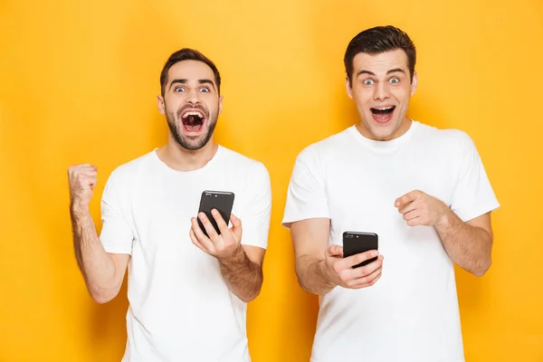 Dos alegres amigos excitados hombres que usan camisetas en blanco — Foto de Stock