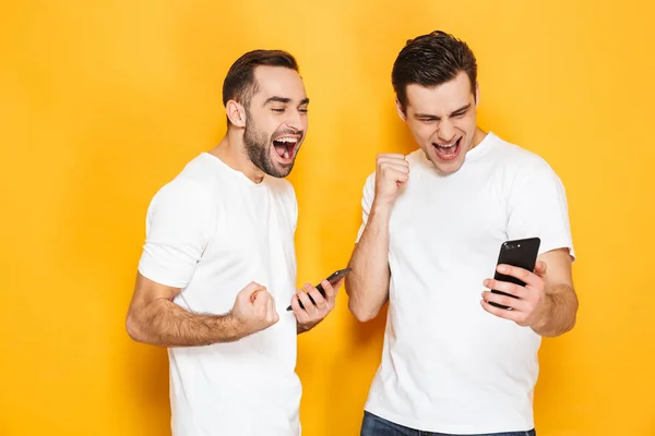 Two cheerful excited men friends wearing blank t-shirts — Stock Photo, Image