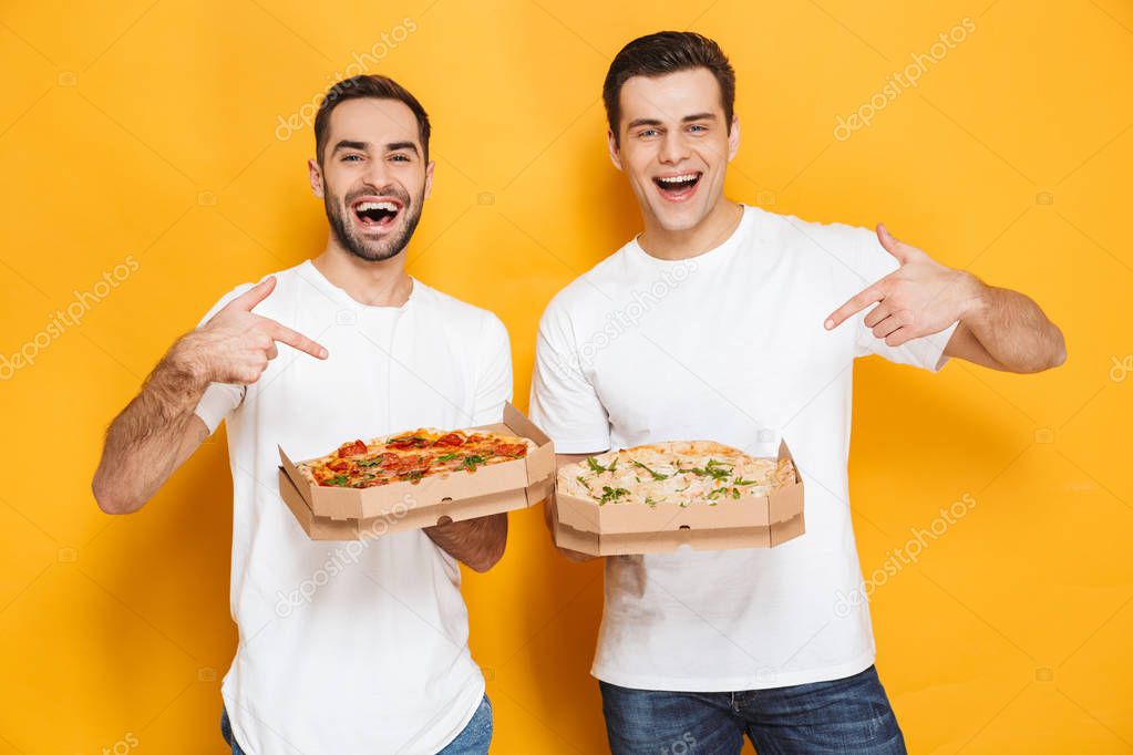 Image of two joyful men bachelors 30s in white t-shirts smiling 