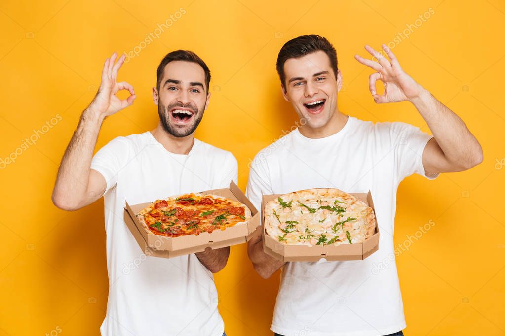 Image of two cheerful men bachelors 30s in white t-shirts smilin