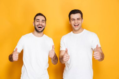 Boş t-shirt giyen iki neşeli heyecanlı erkek arkadaşlar