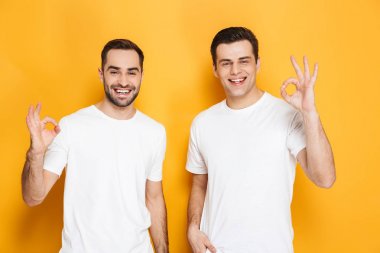 Boş t-shirt giyen iki neşeli heyecanlı erkek arkadaşlar