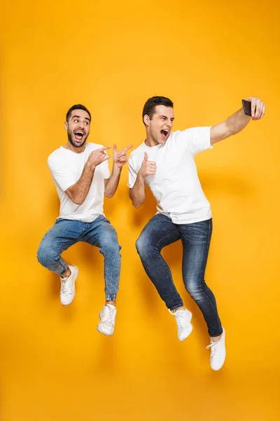 Comprimento total de dois animados amigos homens alegres — Fotografia de Stock