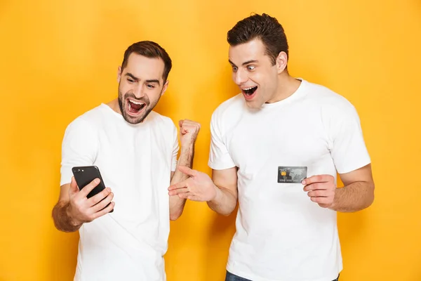 Dois animados homens alegres amigos vestindo camisetas em branco — Fotografia de Stock