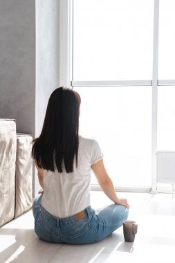 Oturunca çay içen büyüleyici Asyalı kızın arkasından portre