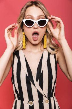 Güzel şok duygusal inanılmaz genç kadın kırmızı mercan arka plan üzerinde izole poz.